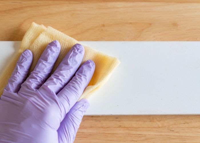 Wiping away the sanding dust with a tack cloth